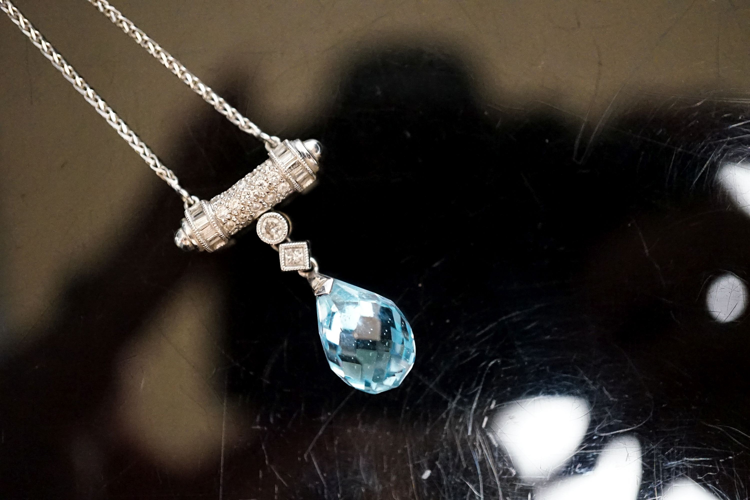 A modern 750 white metal, facet cut pear shaped aquamarine and diamond chip set drop pendant, pendant 25mm, chain 40cm, gross weight 6.2 grams.